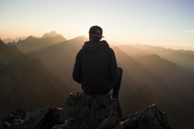 Inspirational photo of person seated on mountain top